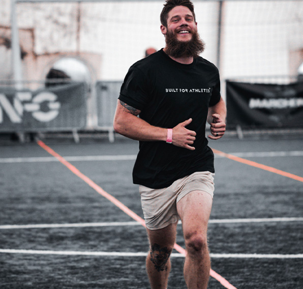 coach in black t-shirt and beige short captured while running